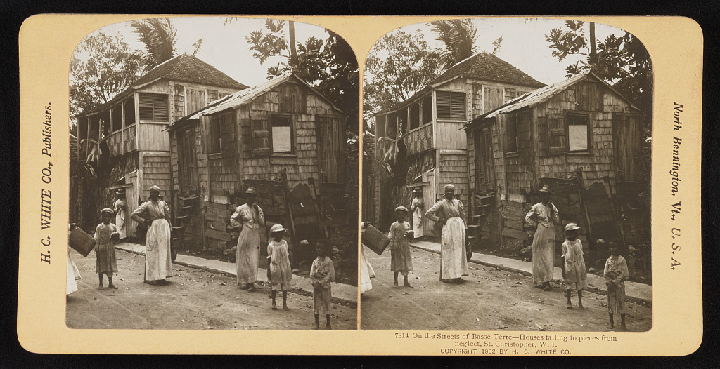 Stereograph of a street in Basseterre, St Kitts, around 1902, showing weathered wooden houses
